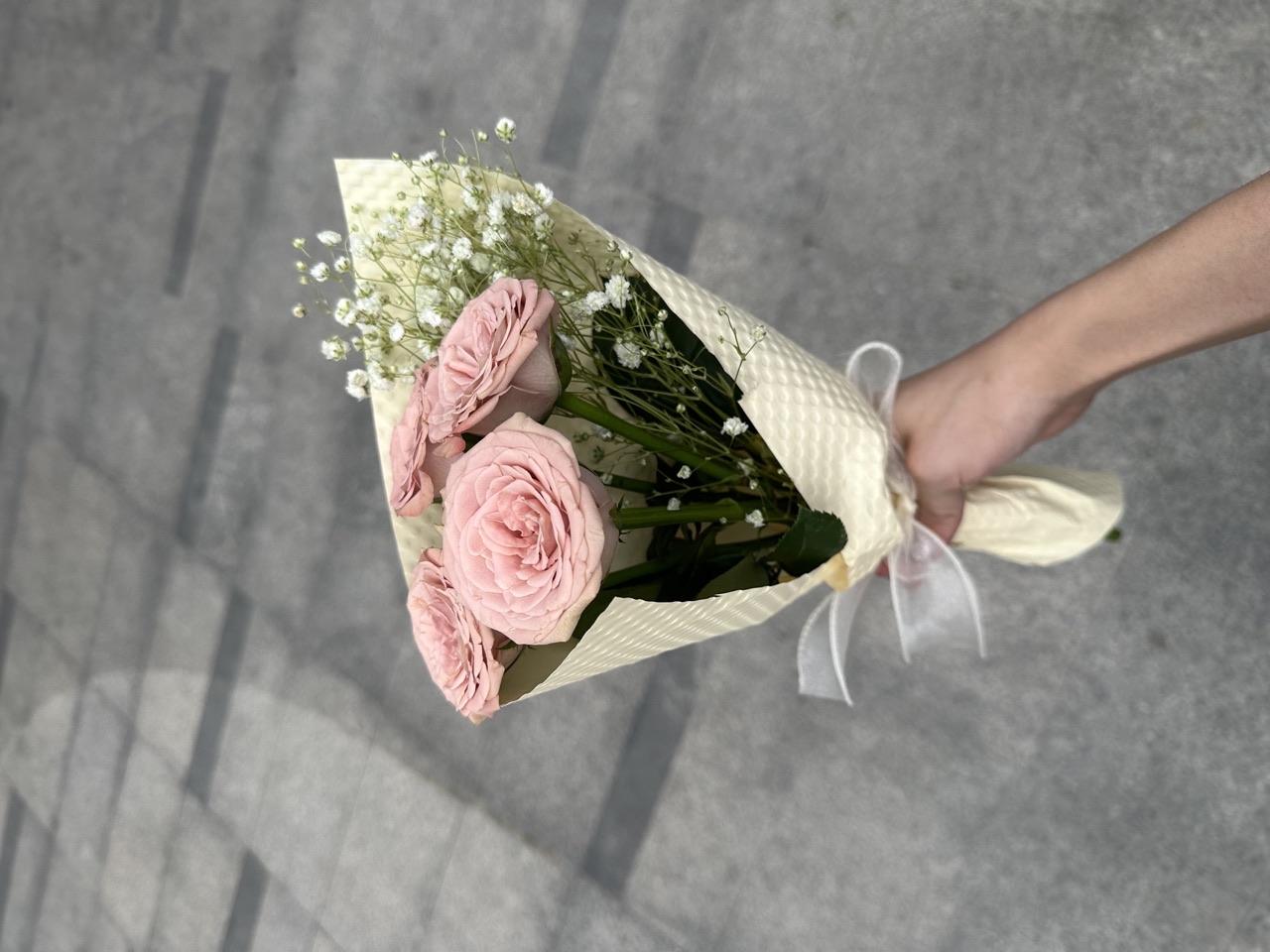 A hand-tied bouquet of pink roses sold at the stall